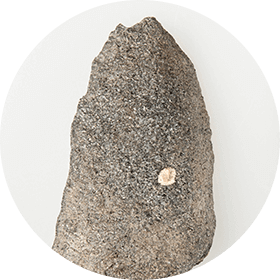 Photograph of an elongated hammerstone made of granite
