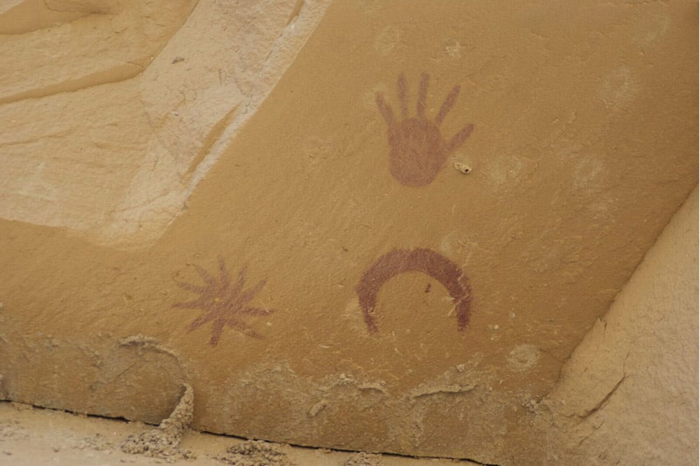 Picture showing pictographs of the Moon, a large star and a handprint at the Chaco Canyon site in New Mexico, United States of America