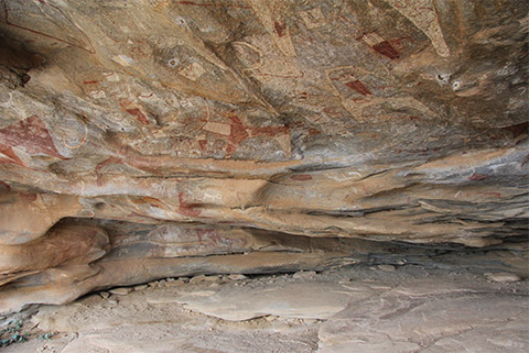 Rocky overhang under which one sees figures of humans and animals carved and highlighted with mineral pigments.