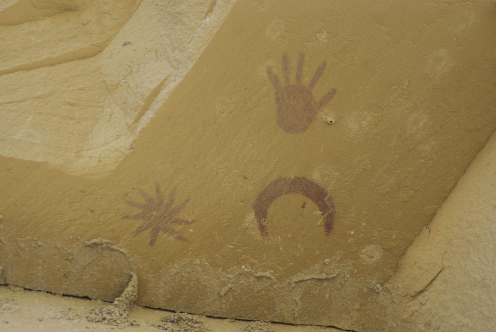 Photographie de pictogrammes représentant la lune, une grande étoile et l'empreinte d'une main. Site de Chaco Canyon, Nouveau-Mexique, États-Unis d’Amérique.